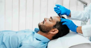 A bearded man gets a scalp injection from a gloved medical professional during Hair Restoration in Hoboken, NJ.
