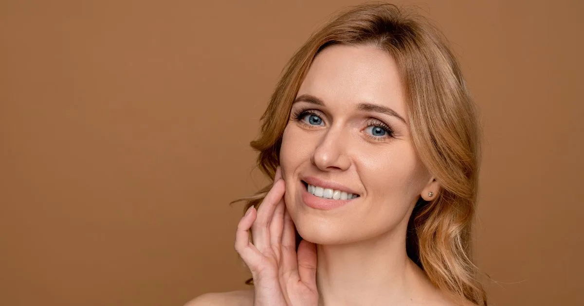 Woman with a smooth, clear complexion touching her face, illustrating the radiant, natural anti-aging results from Rejuran in Hoboken, NJ.
